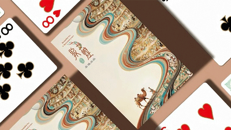 Beautiful for a Thousand Years playing cards with cream-colored backs, flowing multicolored ribbons, and intricate illustrated scenes